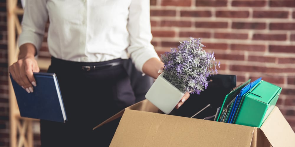 Woman packing box with belongings after getting laid off