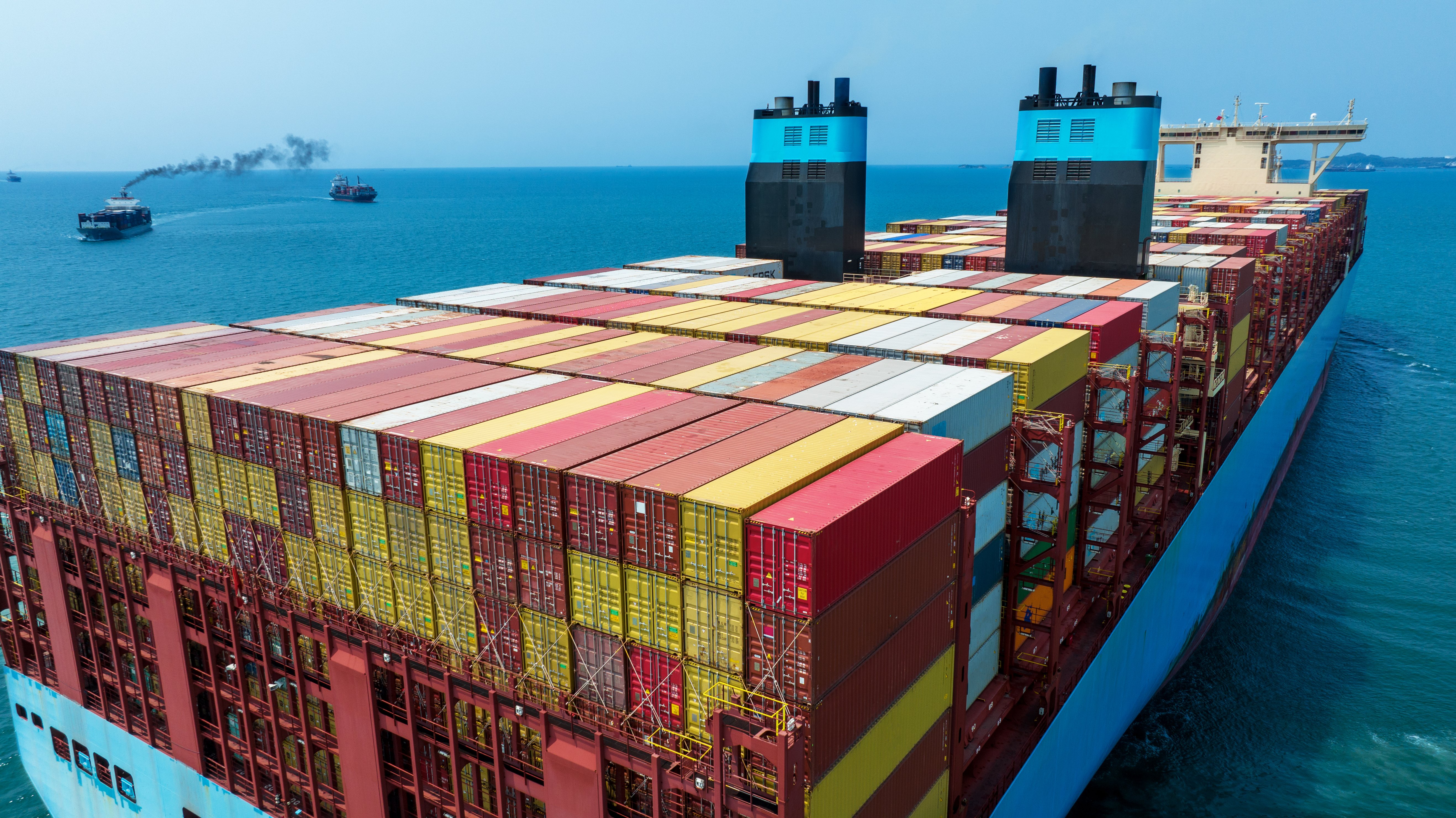 The stern of a large cargo ship loaded with containers.
