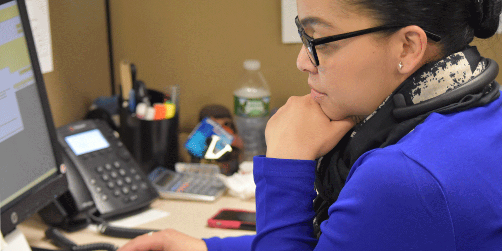 Customer service representative looking at her computer screen.