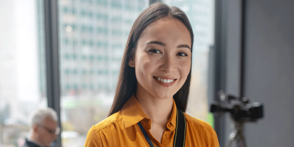 Young dark haired woman smiling at the camera.