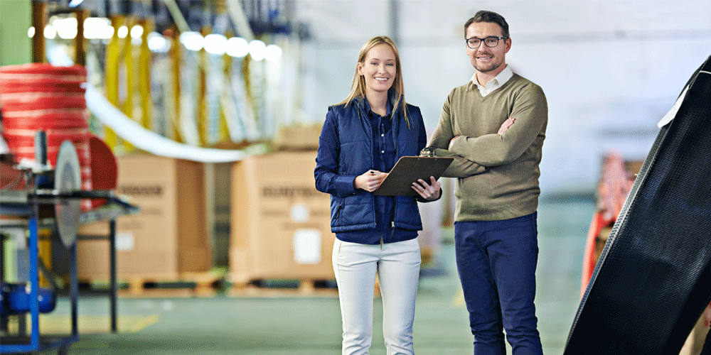 Two sales associates standing in a warehouse.