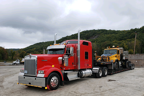 low boy trailer hauling machinery 