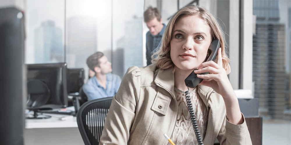 Young woman at her desk on the phone.